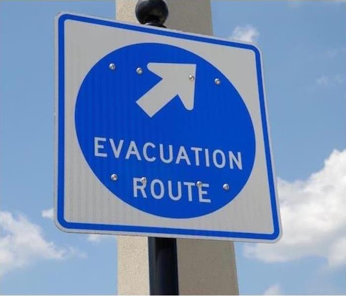A sign reads "Hurricane Evacuation" with sky in background
