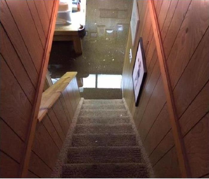 A view down a set of stairs to a flooded basement
