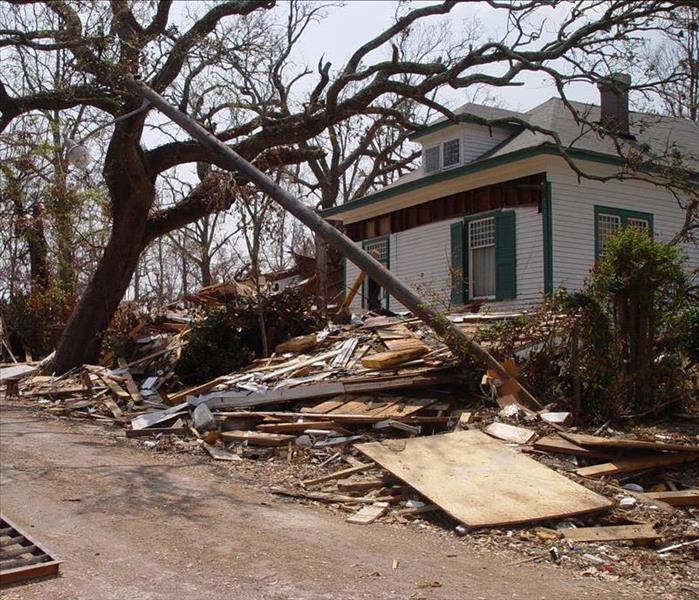 A house is surrounded by damage from a hurricane