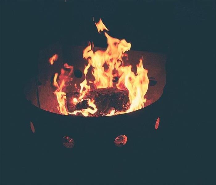 A fire burns at night in a fire pit