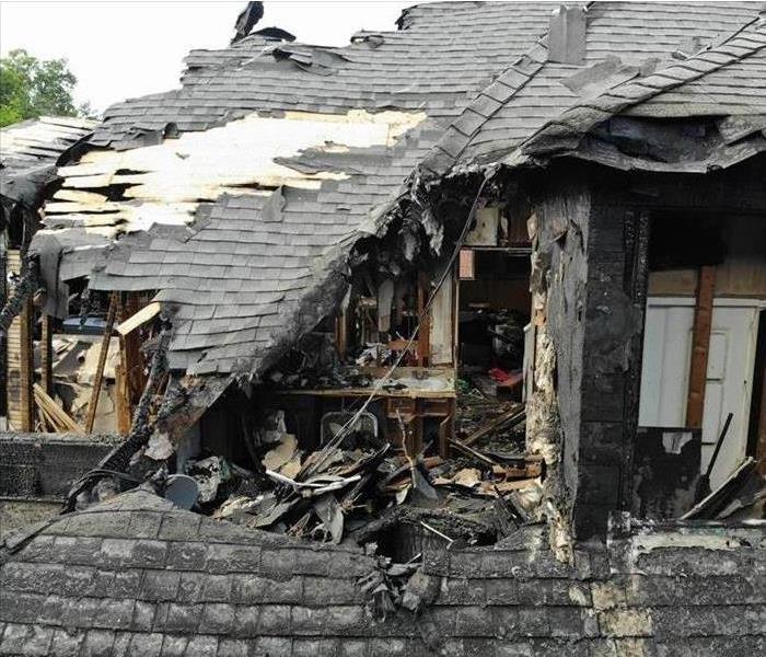 A house damaged by fire with a collapsed roof
